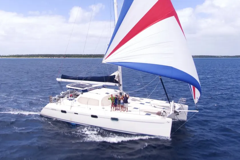 A catamaran under a red, white and blue spinnaker