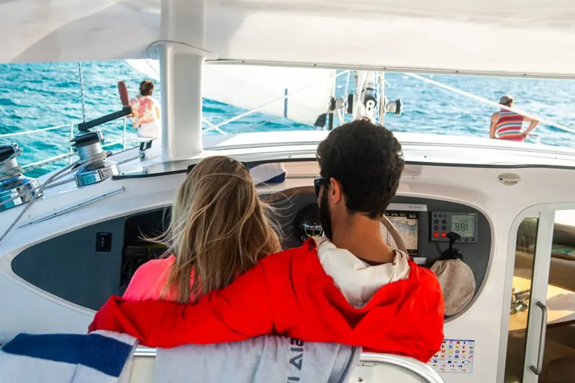 Two cruisers at the helm of a catamaran